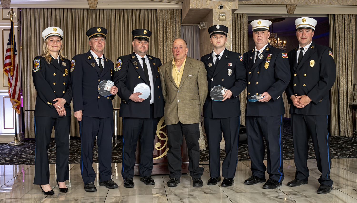 Four members of the Eastport Fire Department received Life Saving Awards, at the department's recent awards dinner, for rescuing Steven Almash, center, when his kayak was swept through Moriches Inlet in February. The recipients who are seen holding their awards were, from the left, Ryan King, Mark Yakaboski, Joe Dalen, and Chief John Dalen. With them are First Assistant Chief Virginia Haughn, far left, and Second Assistant Chief Chris Hulse, at right.  COURTESY EASTPORT FIRE DEPARTMENT