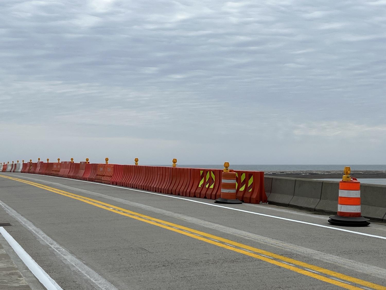 The Ponquogue Bridge was reopened to vehicle and bicycle traffic on Tuesday, but there is now a 5 ton weight limit and barriers have been put in place to keep vehicles away from the western edge of the roadway near the bridge's apex. Engineers from New York State found signs of deterioration in the concrete girders that support the roadway during an October inspection and the county is now working on a permanent repair that will restore the bridge's full weight allowances. DANA SHAW