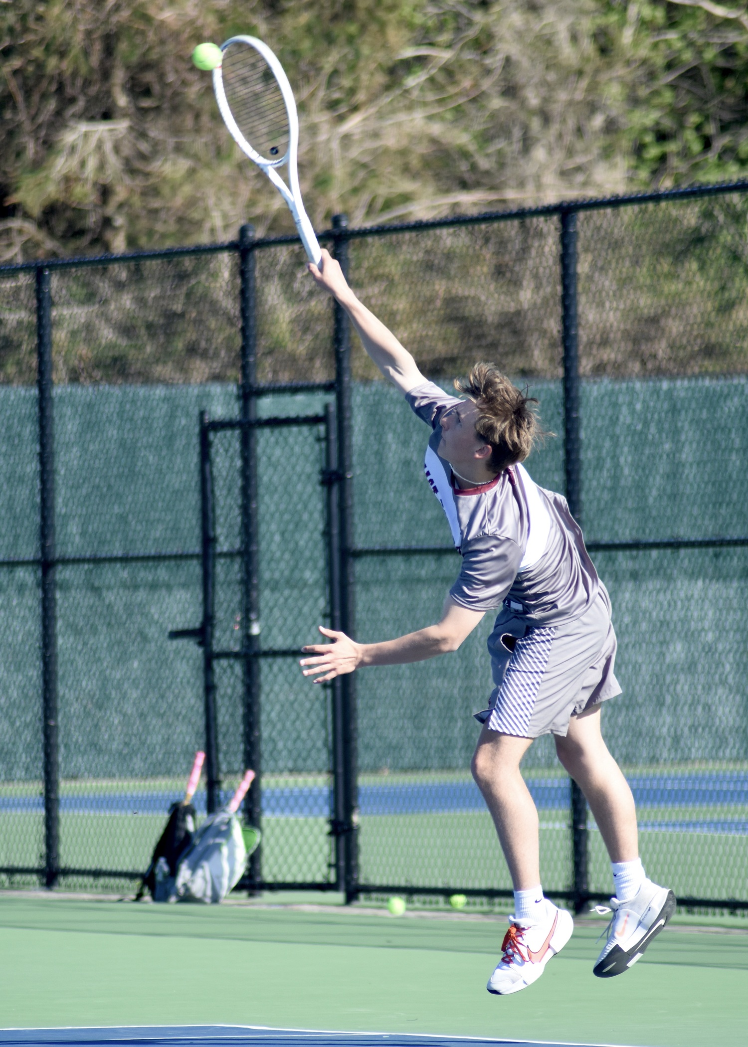 Senior C.J. Baumrind serves. DESIRÉE KEEGAN