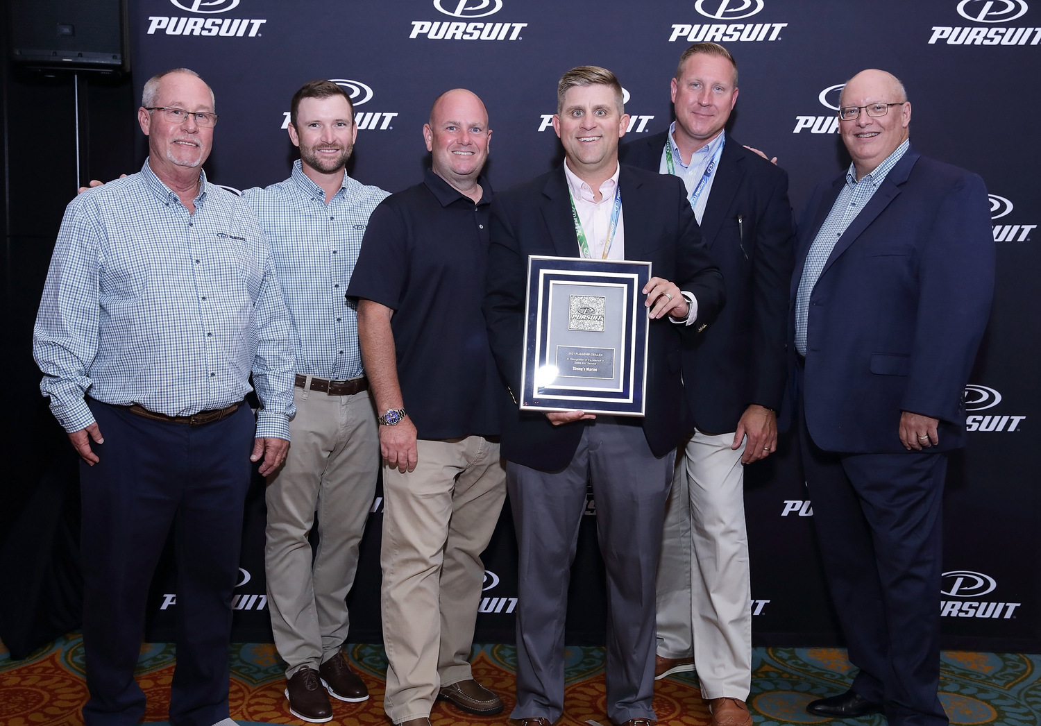 Receiving the Pursuit Top 10 Dealer  in 2021; middle Chris Suter, sales manager, right Dave Russel, sales consultant and left Brian Hyland, sales consulant.  COURTESY STRONG'S MARINE