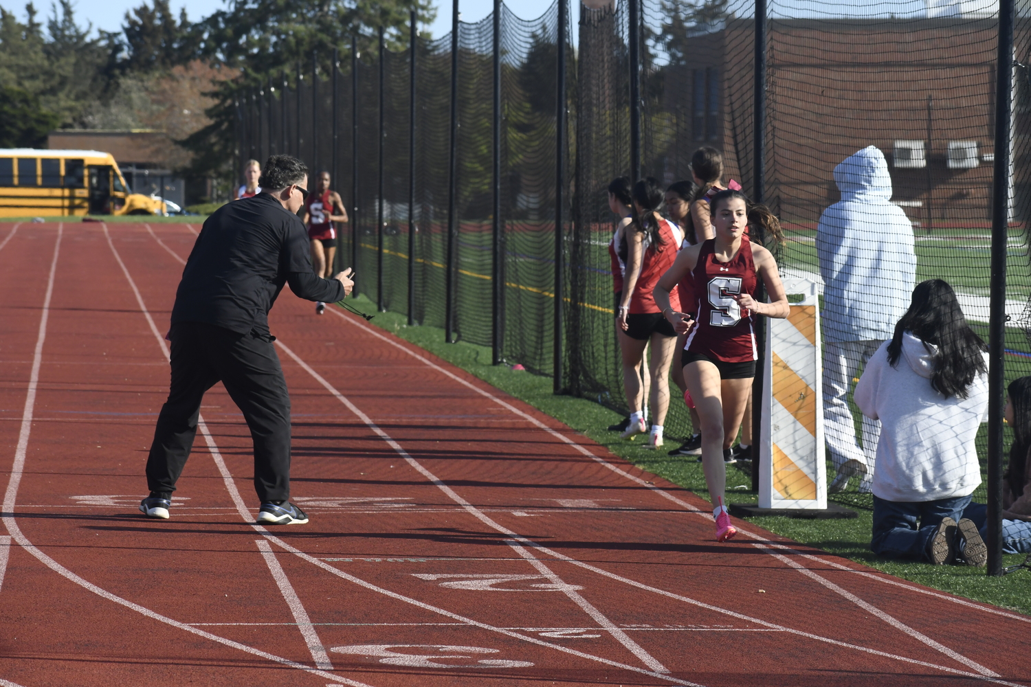 Emma Suhr gets her split time in the 800-meter race from head coach Eddie Arnold.   DREW BUDD