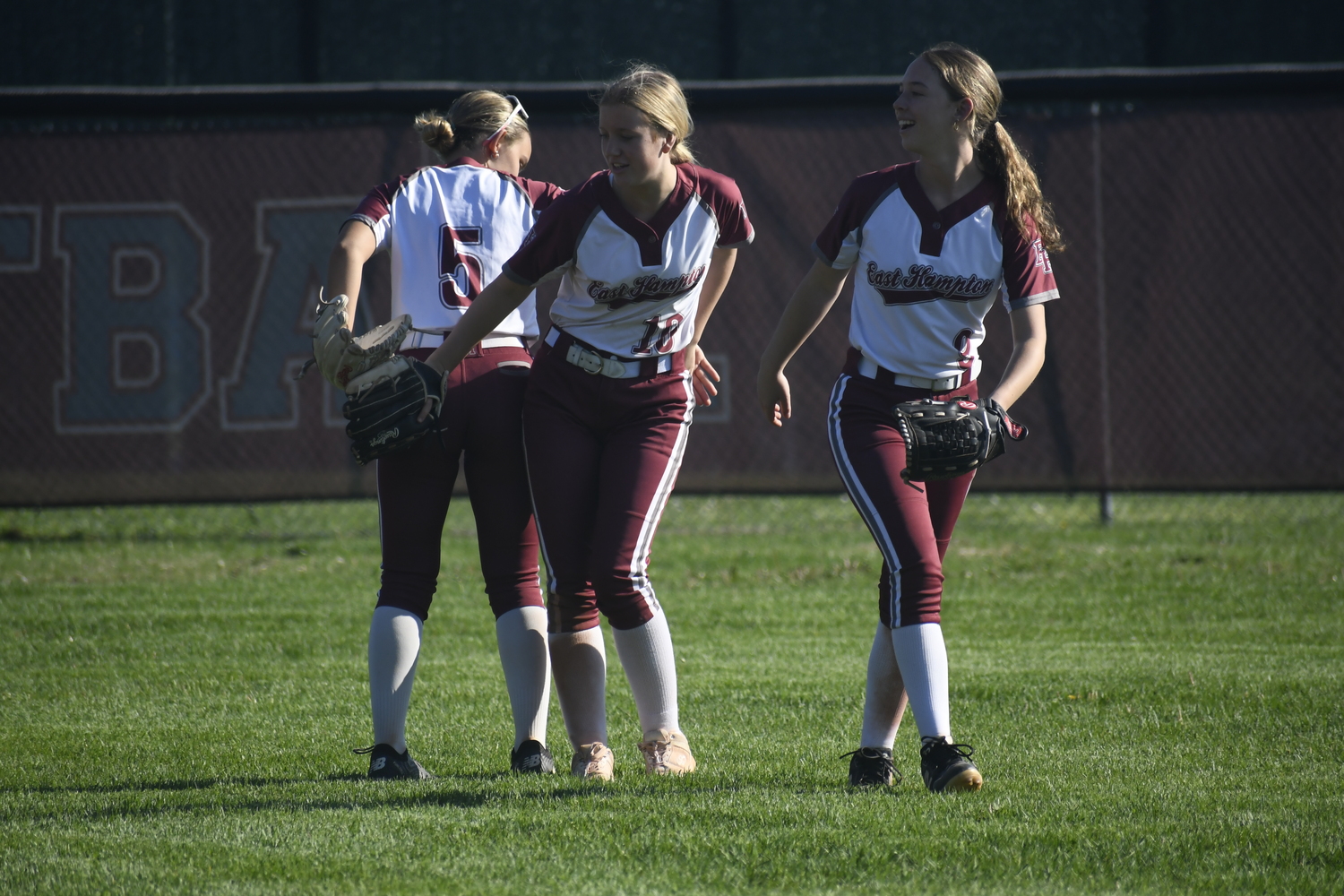 Brynley Lys, left, Lydia Rowan and Hailey Rigby do their handshake just prior to the start of an inning.   DREW BUDD