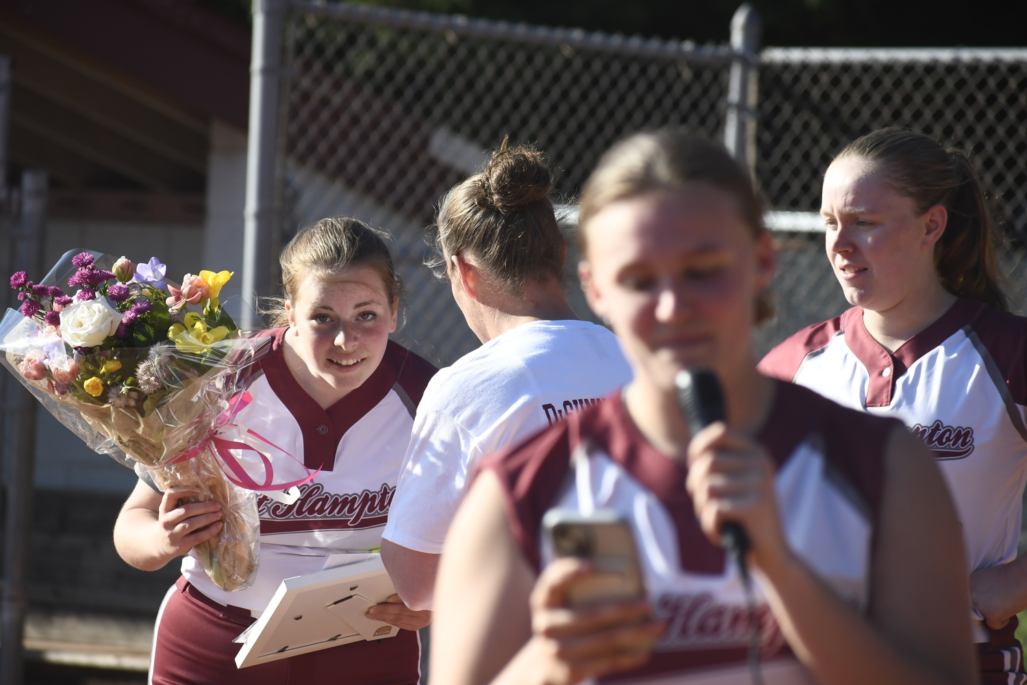 Mackenzie Lenahan peers in to listen to what head coach Melissa Edwards has to say as Isabel Briand is speaking.  DREW BUDD