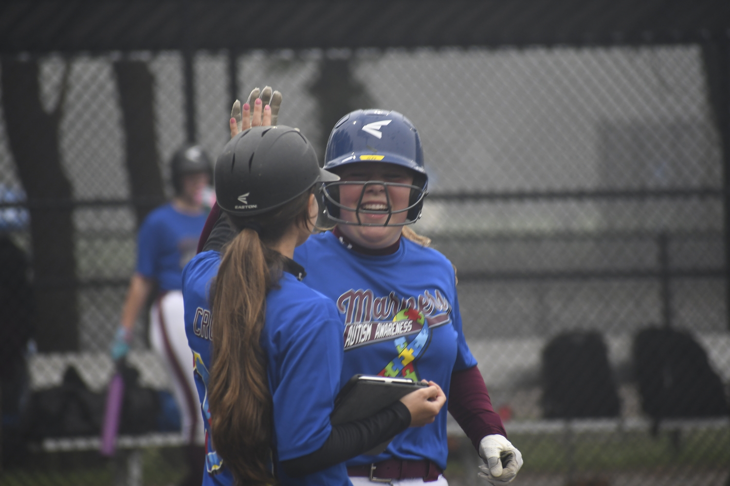 Taylor Olsen gets a high-five from assistant coach Taylor Craft after she reaches first base.   DREW BUDD