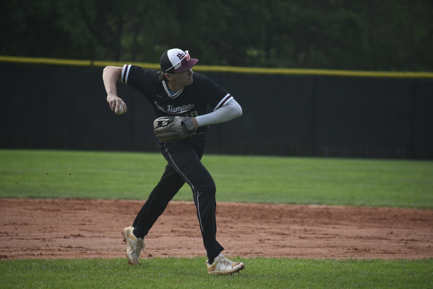East Hampton junior third baseman fires to first base to end the bottom of the first inning.  DREW BUDD