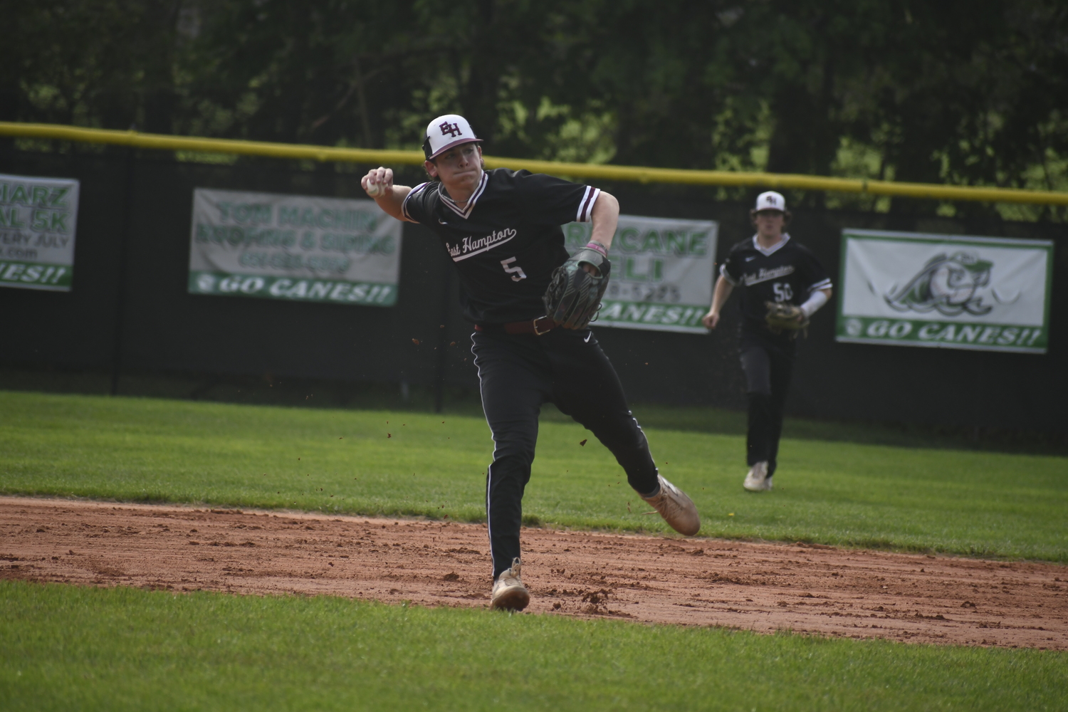 East Hampton senior shortstop Hudson Meyer fields a ground ball and throws to first base for an out.   DREW BUDD