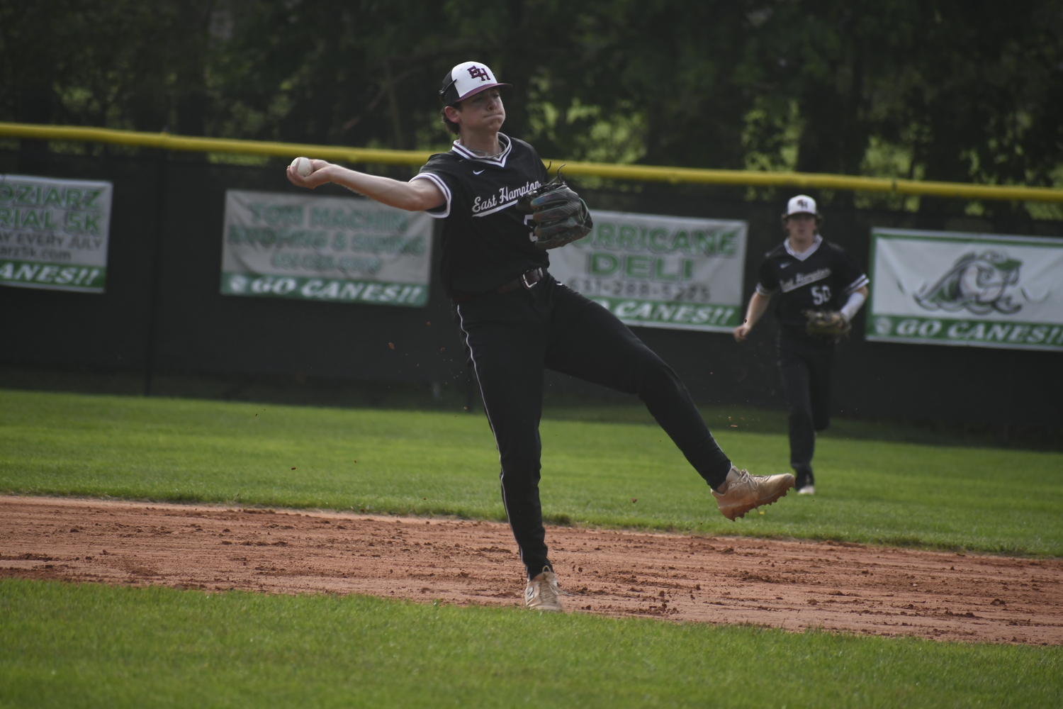 East Hampton senior shortstop Hudson Meyer fields a ground ball and throws to first base for an out.   DREW BUDD