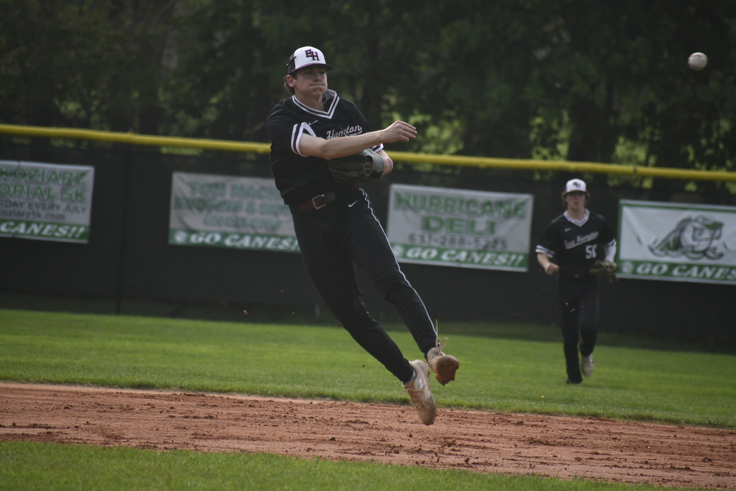 East Hampton senior shortstop Hudson Meyer fields a ground ball and throws to first base for an out.   DREW BUDD