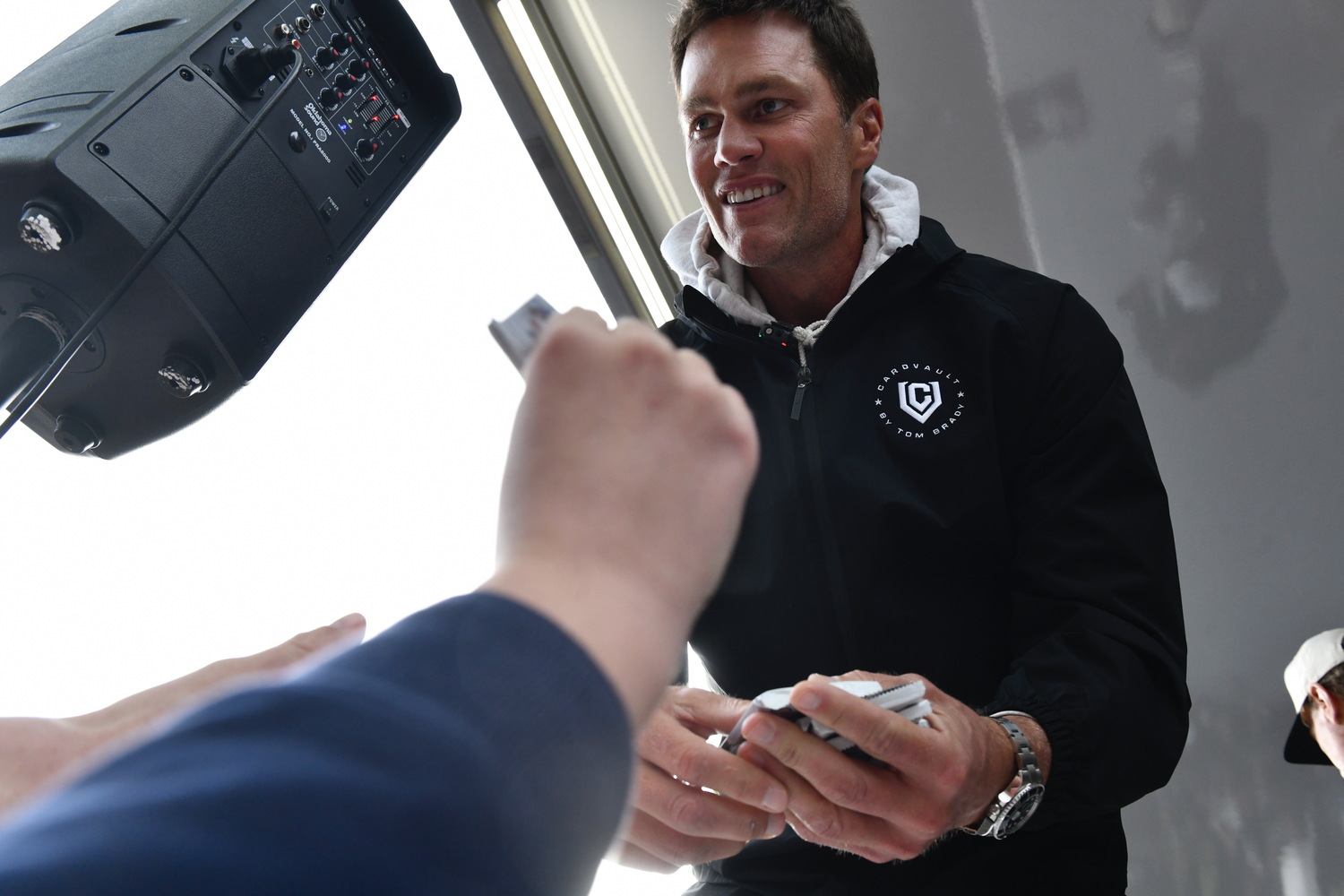 Tom Brady hands out trading cards to fans in attendance on Thursday.   DANA SHAW