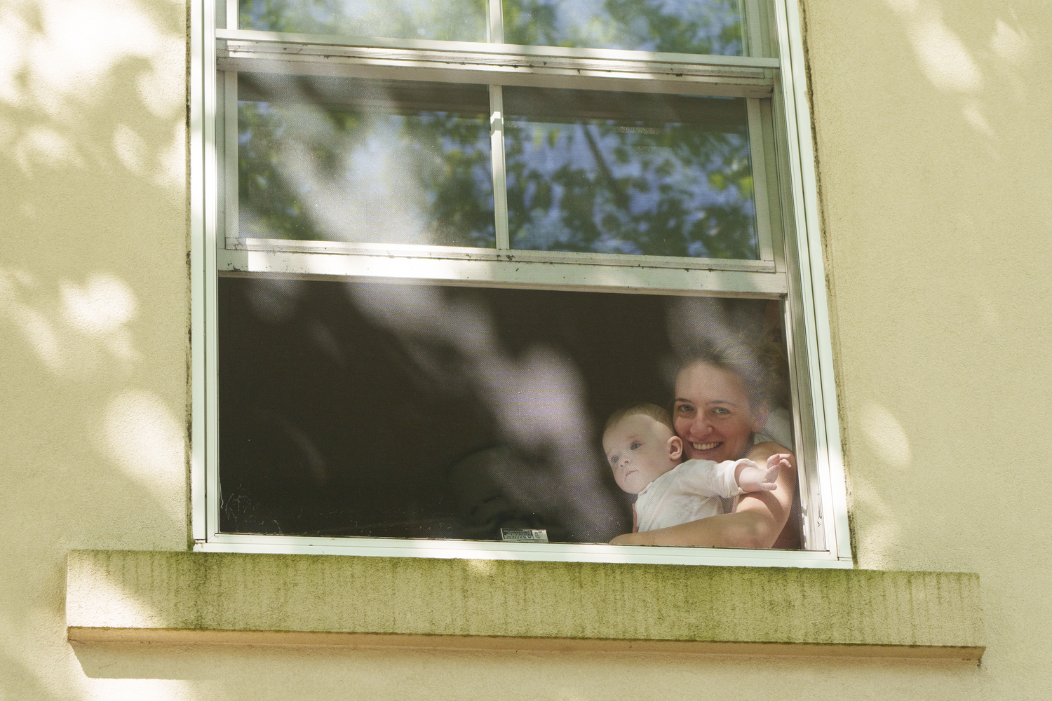 Eva Glyzewski and her daughter Zoe watch the Sag Harbor Memorial Day parade from the window of their apartment. LORI HAWKINS PHOTOS