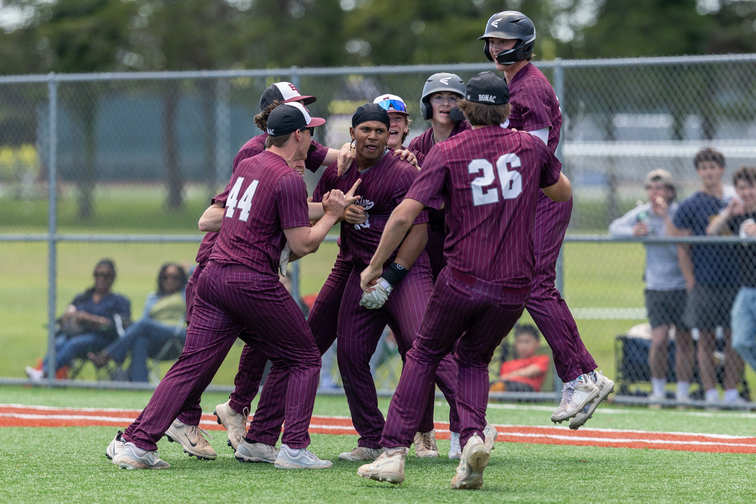 The Bonackers mob Victoreddy Aguero, who's base hit to left field scored Hudson Meyer from second base for the 2-1 walk-off victory over Half Hollow Hills West on Monday.   RON ESPOSITO