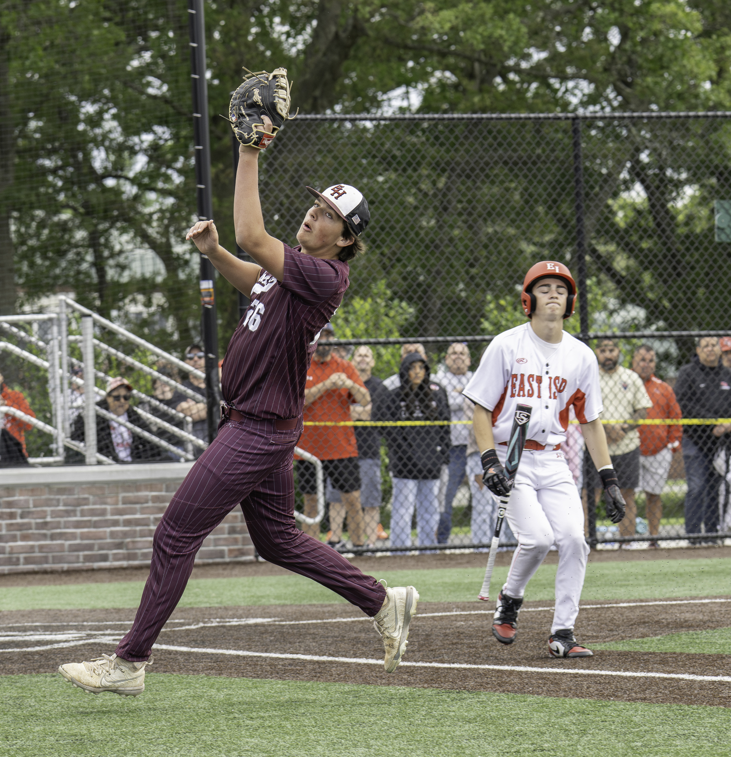 East Hampton first baseman Tiger Brew catches a pop up in foul territory.   MARIANNE BARNETT