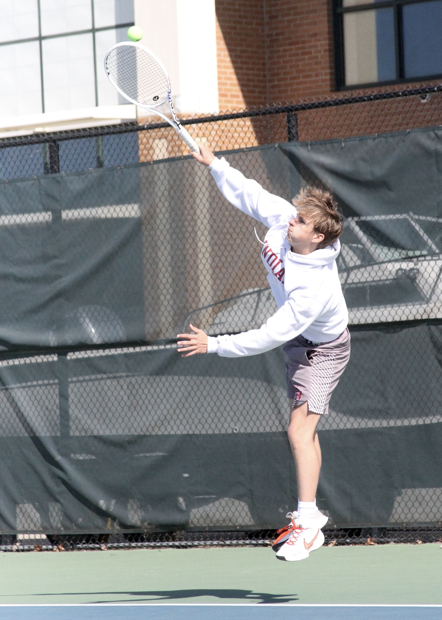 Senior C.J. Baumrind serves. DESIRÉE KEEGAN