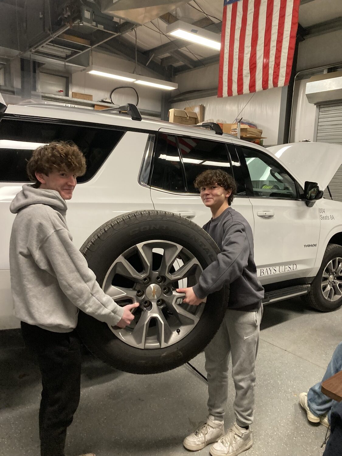 As part of their driver’s education course, Hampton Bays students are learning how to change flat tires, put air in a tire and hook up jumper cables. Driver’s education teacher Katie Drohan added the hands-on lessons to provide students with additional knowledge about roadside safety. Students, including Brendyn Molnar and Nico Carone, were appreciative of the experience. COURTESY HAMPTON BAYS SCHOOL DISTRICT