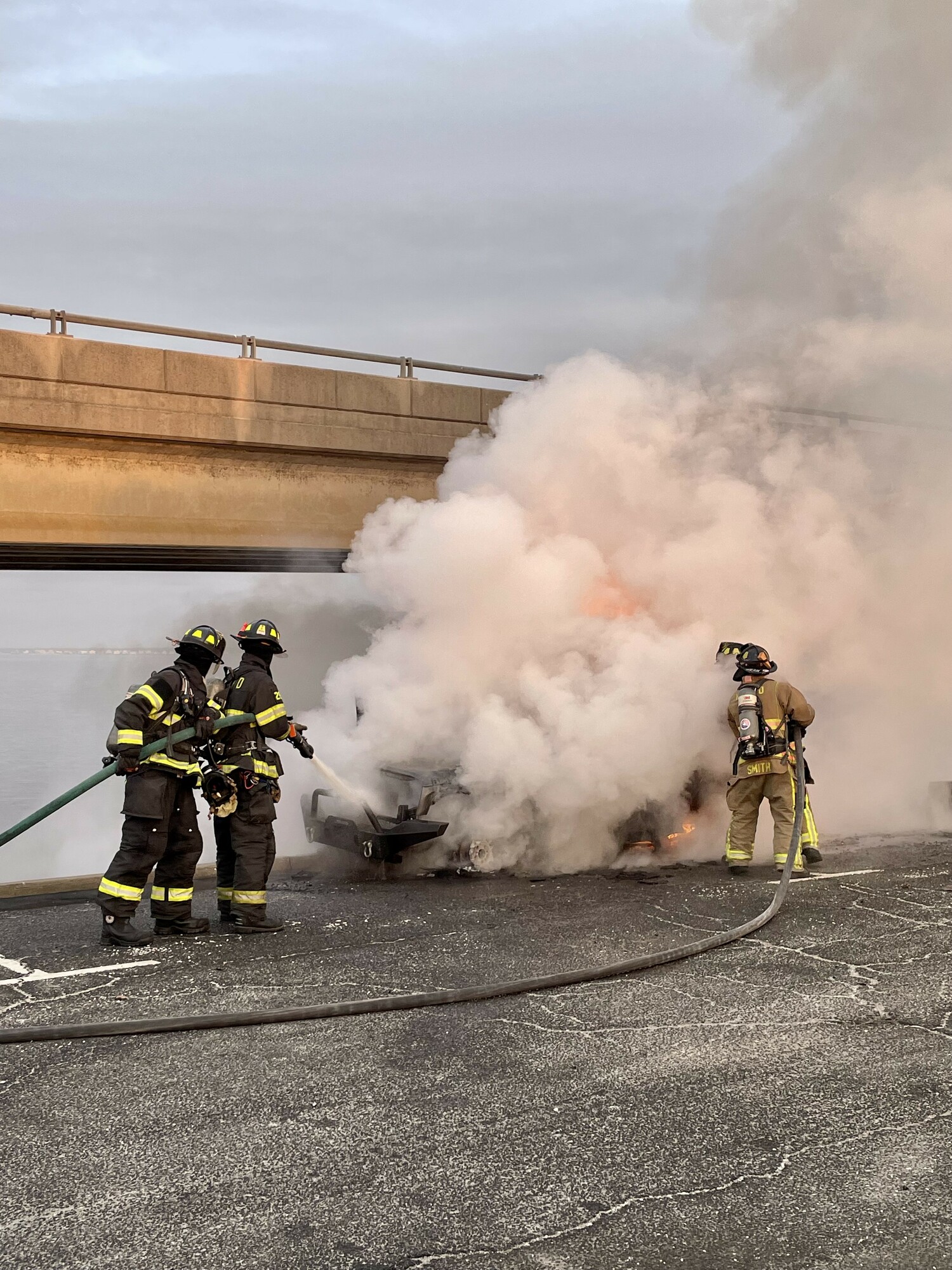 Hampton Bays Fire Department firefighters put out a car blaze near Ponquogue Bridge on Sunday morning. COURTESY HBFD