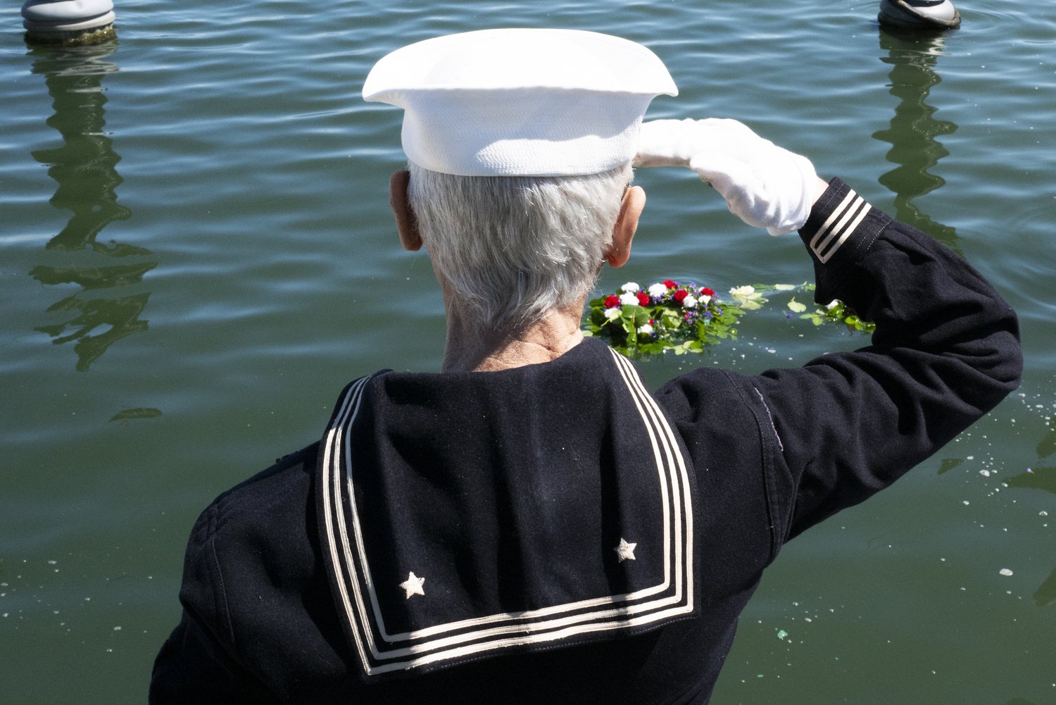 John Capello's salute frames the wreath that commemorates those who lost their lives at sea at Sag Harbor's Memorial Day observance, LORI HAWKINS PHOTOS