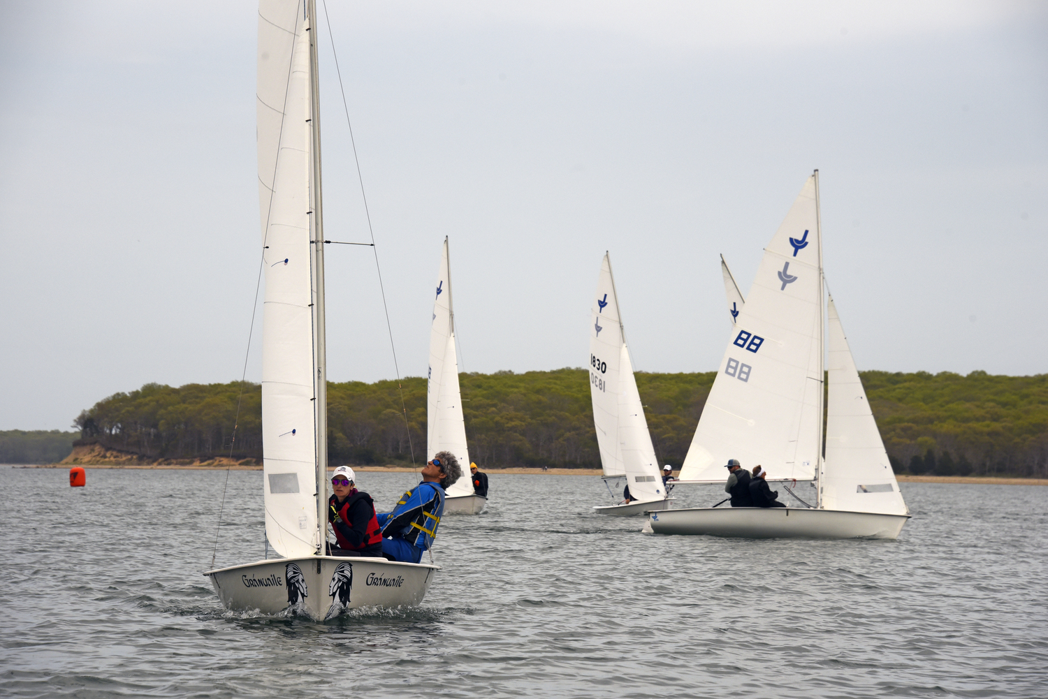 David Whelan and Sinéad FitzGibbon out in front, about to T-bone the photo boat! Boat #88, on the opposite tack, is last year’s winning son/mom team Seth Barrows and Joan Butler. Sunday, racing against 13 boats, they finished in a respectable third place. MICHAEL MELLA