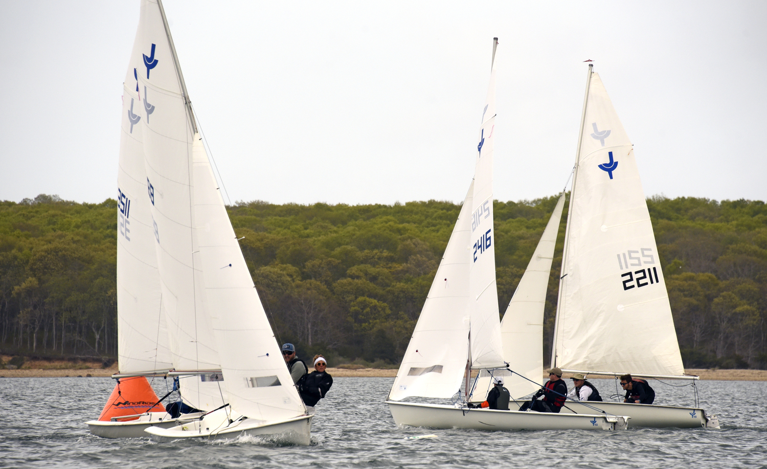 Seth Barrows and Joan Butler, hiking out after rounding the weather mark, while #2416 Colin Schneider and Andrew Schneider and second place overall father/son duo #2211 Will and Paul Priebe approach the mark.
MICHAEL MELLA