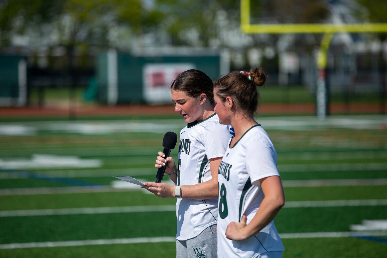 Senior Maya Farnan reads junior Dagny Beasley's speech on the Westhampton Beach girls lacrosse team's partnership with the nonprofit Morgan's Message prior to the Hurricanes game against Rocky Point May 2. TIM BEASLEY