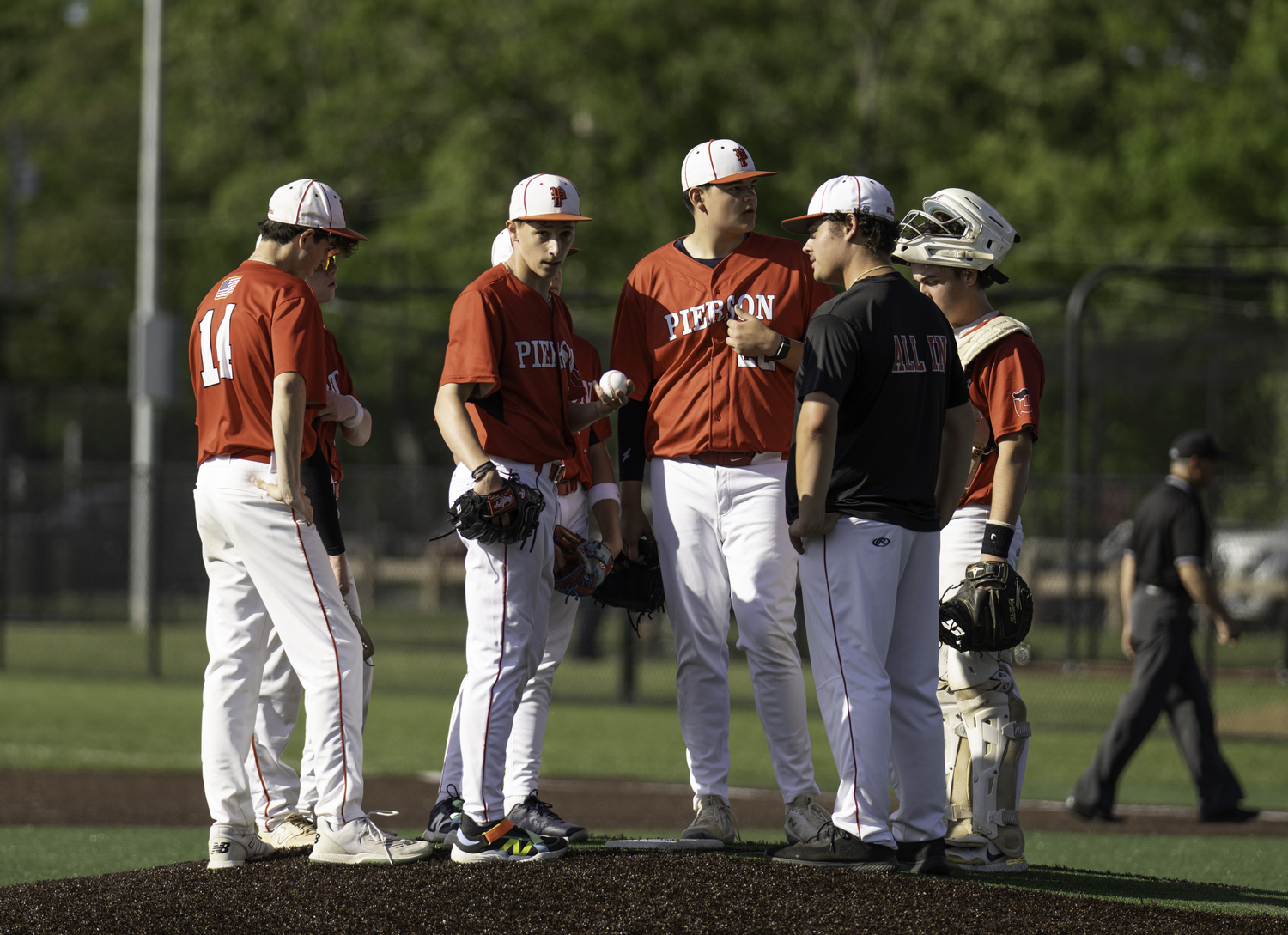 Assistant coach Tyler Laborne meets with the infield at the mound during a rough inning. MARIANNE BARNETT