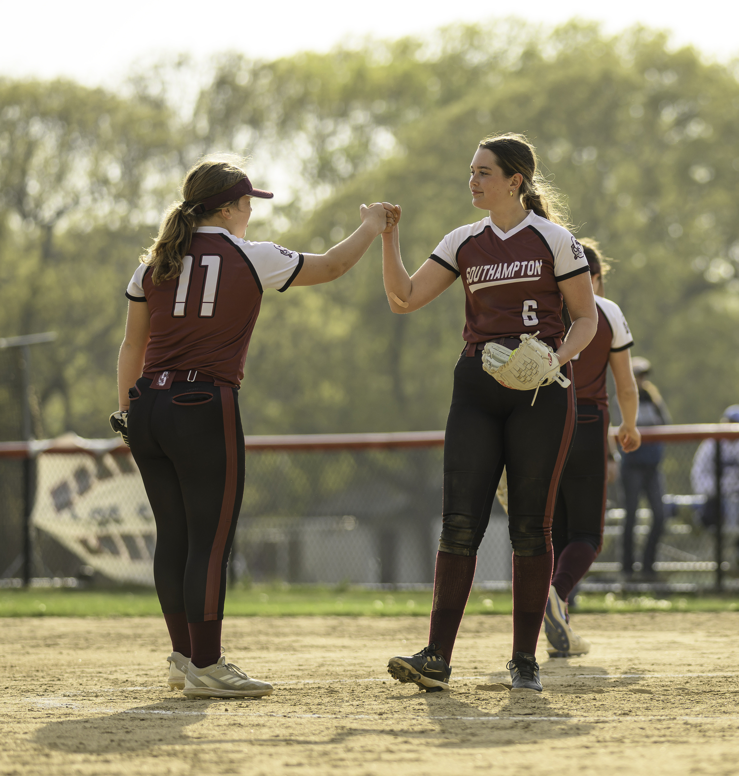 Shortstop Natalie Glanz, left, gives a pound to pitcher Avery Greene. MARIANNE BARNETT