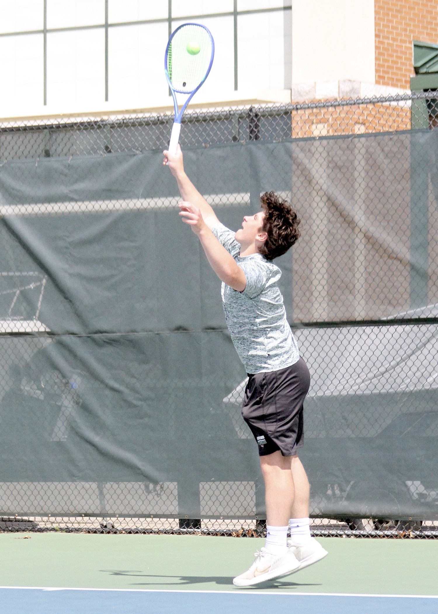 Freshman Ian Besser serves. DESIRÉE KEEGAN