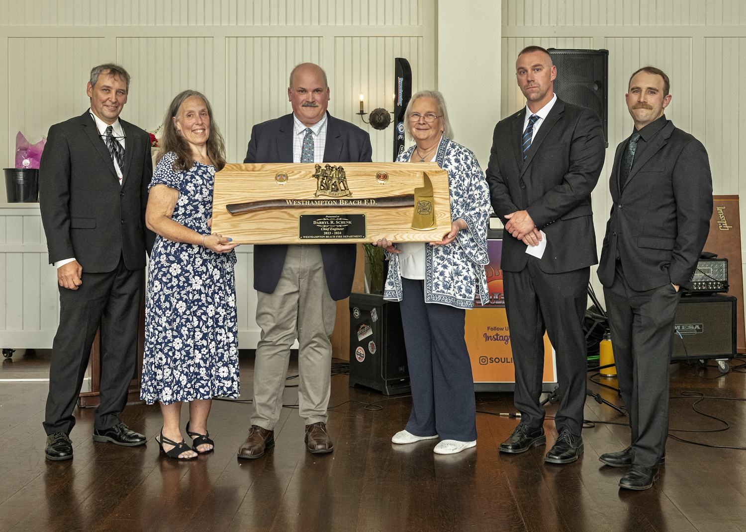 Ex-chief Darryl Schunk (third from left) received a plaque representing the department’s gratitude for his four years as chief engineer during two terms as chief. From left, Chief Larry Saccente, Chief Schunk’s wife Tonya, his mother Cynthia, Third Assistant Chief Joey Gordon, and First Assistant Chief Jeff Wachenfeld. COURTESY WESTHAMPTON BEACH FIRE DEPARTMENT