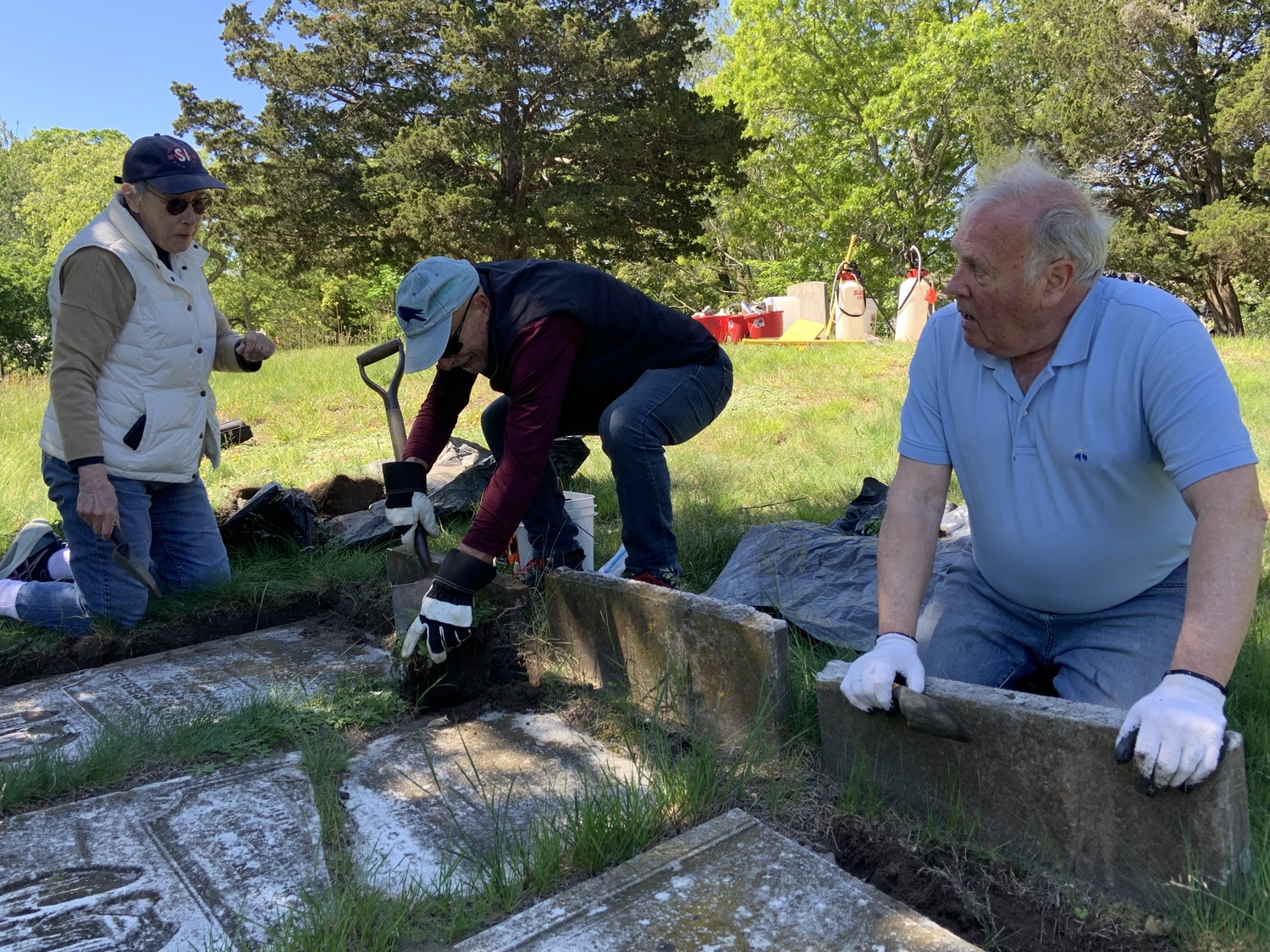 Karen Kiaer, Rav Freidel, and Zach Studentroth, president of the Sag Harbor Historical Museum, dig out Beebee family headstones that were knocked over years ago. STEPHEN J. KOTZ
