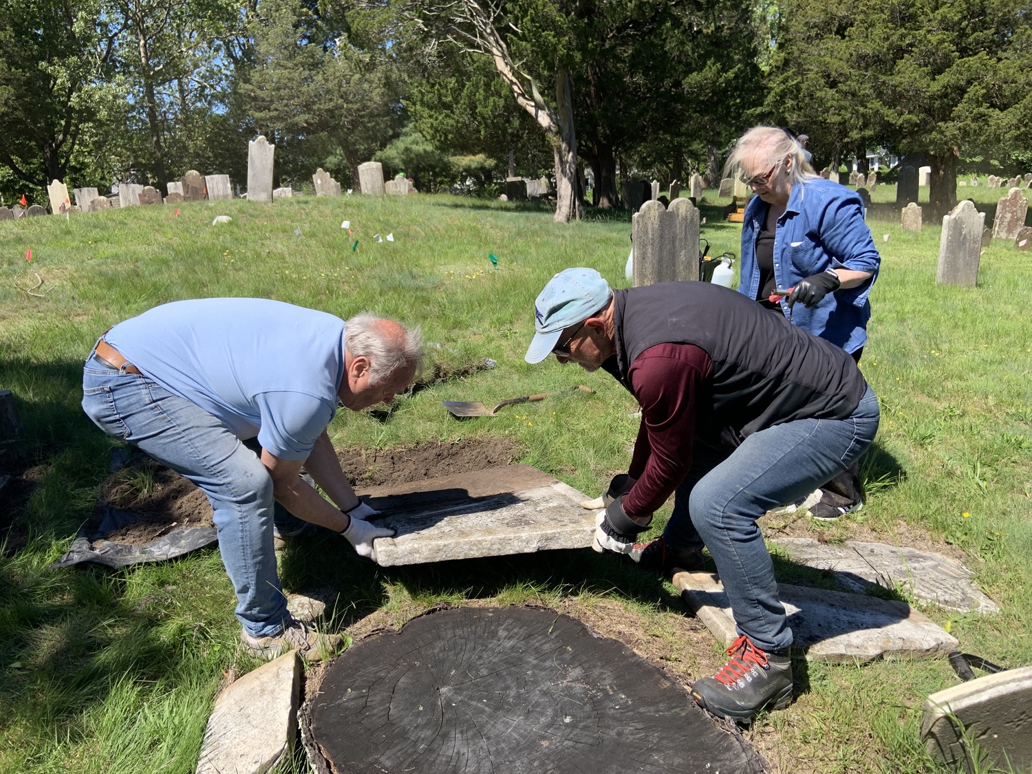 Zach Studenroth, left, and Rev Dreidel pull a broken headstone off the ground. STEPHEN J. KOTZ