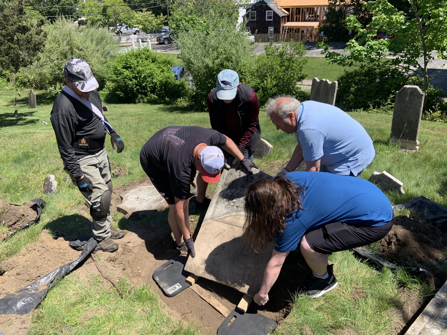 A team of volunteers lifts a broken Beebee family headstone back into position. STEPHEN J. KOTZ