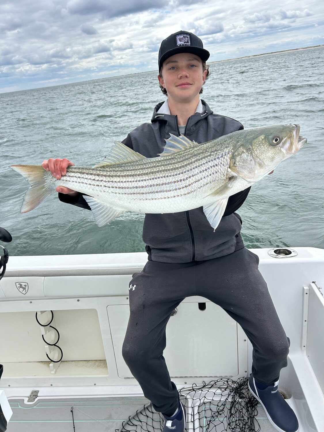 Luke Gobler caught this nice striped bass fishing the boils of fish in the ocean off Hampton Bays last week. CHRIS GOBLER
