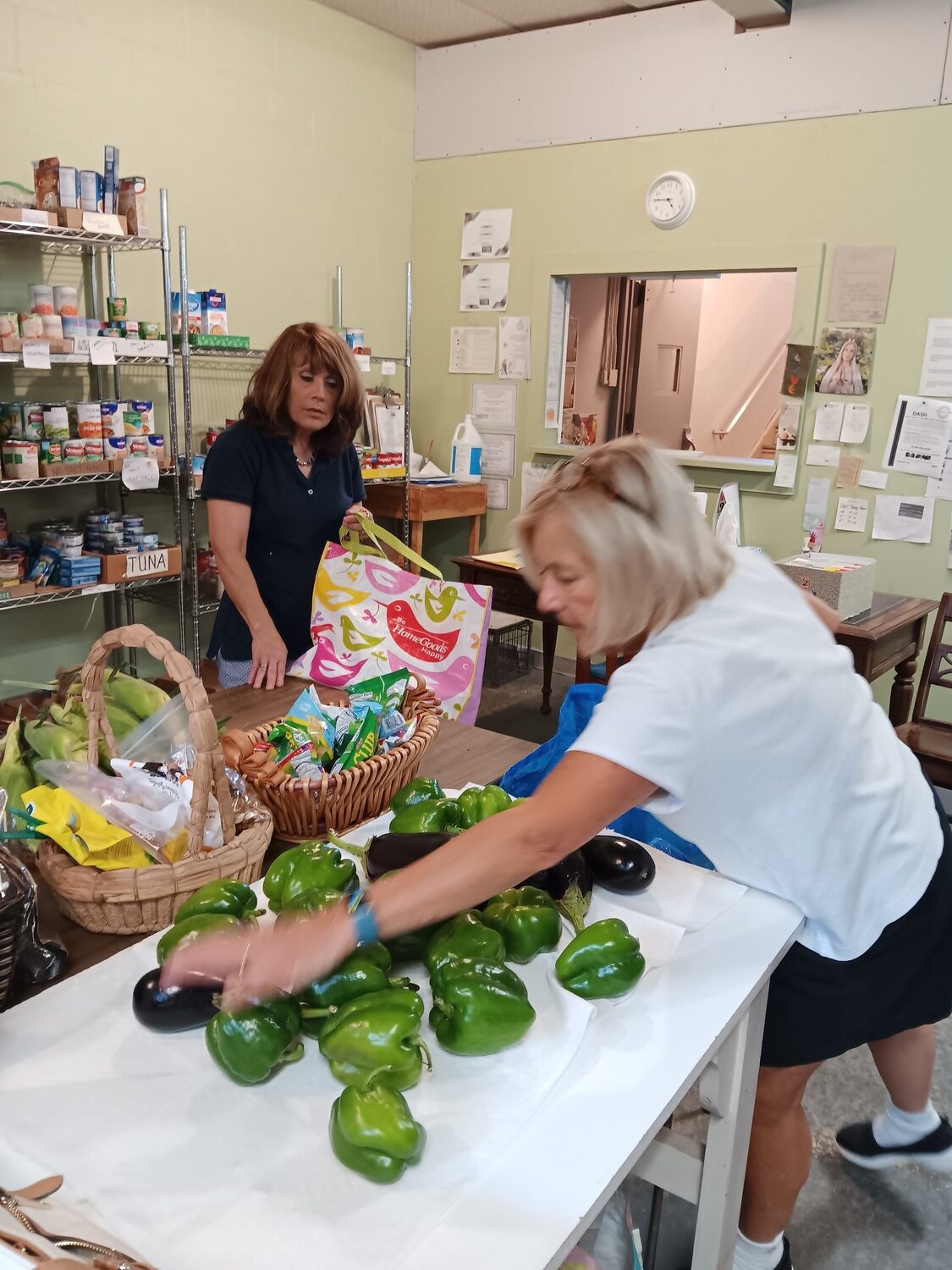 Maria Fedele, Executive Director of the Food Bank at North Fork Parish Outreach in Greenport, bags food with a volunteer.