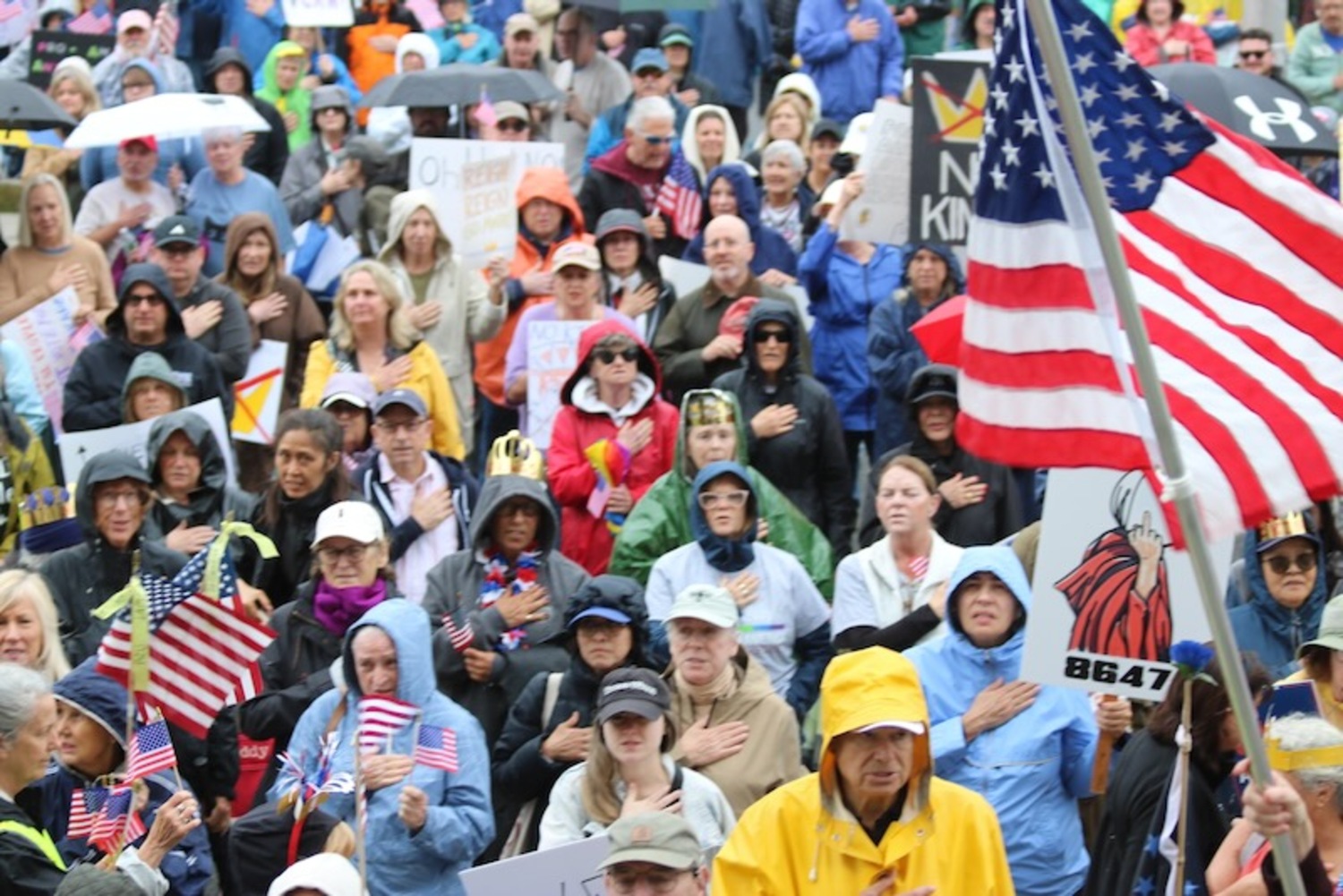 Protesters recited the Pledge of Allegiance at the start of the rally, acknowledging Flag Day. Many waved small American flags distributed by rally organizers. RiverheadLOCAL/ Denise Civiletti