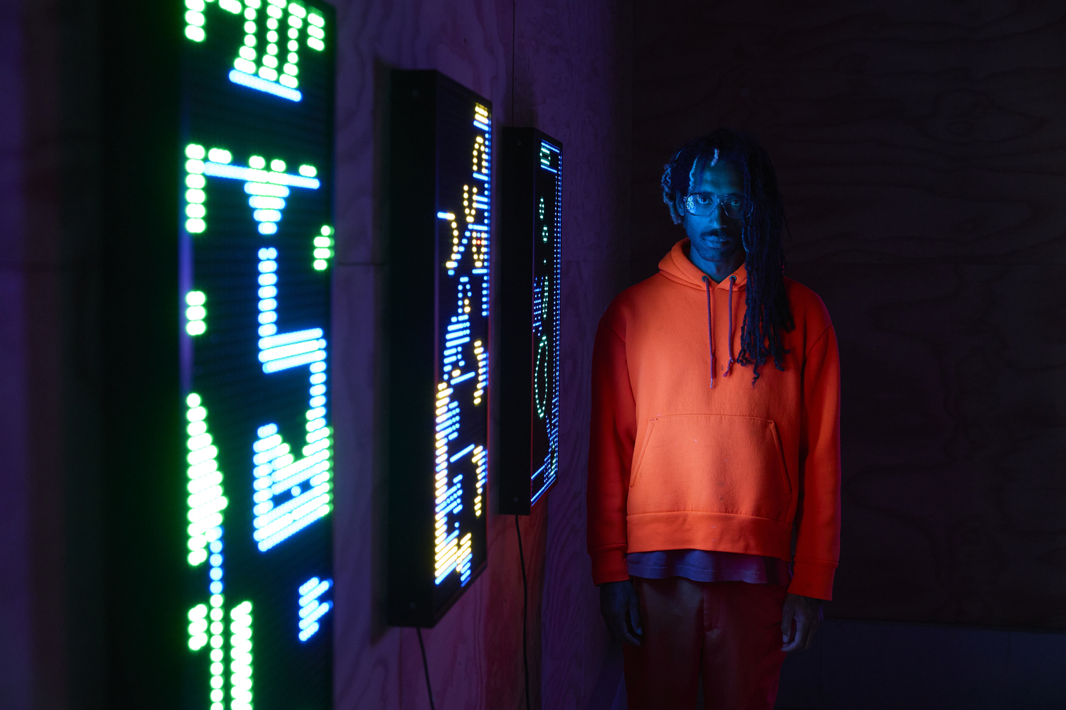 Yung Jake in front of new works on view in 