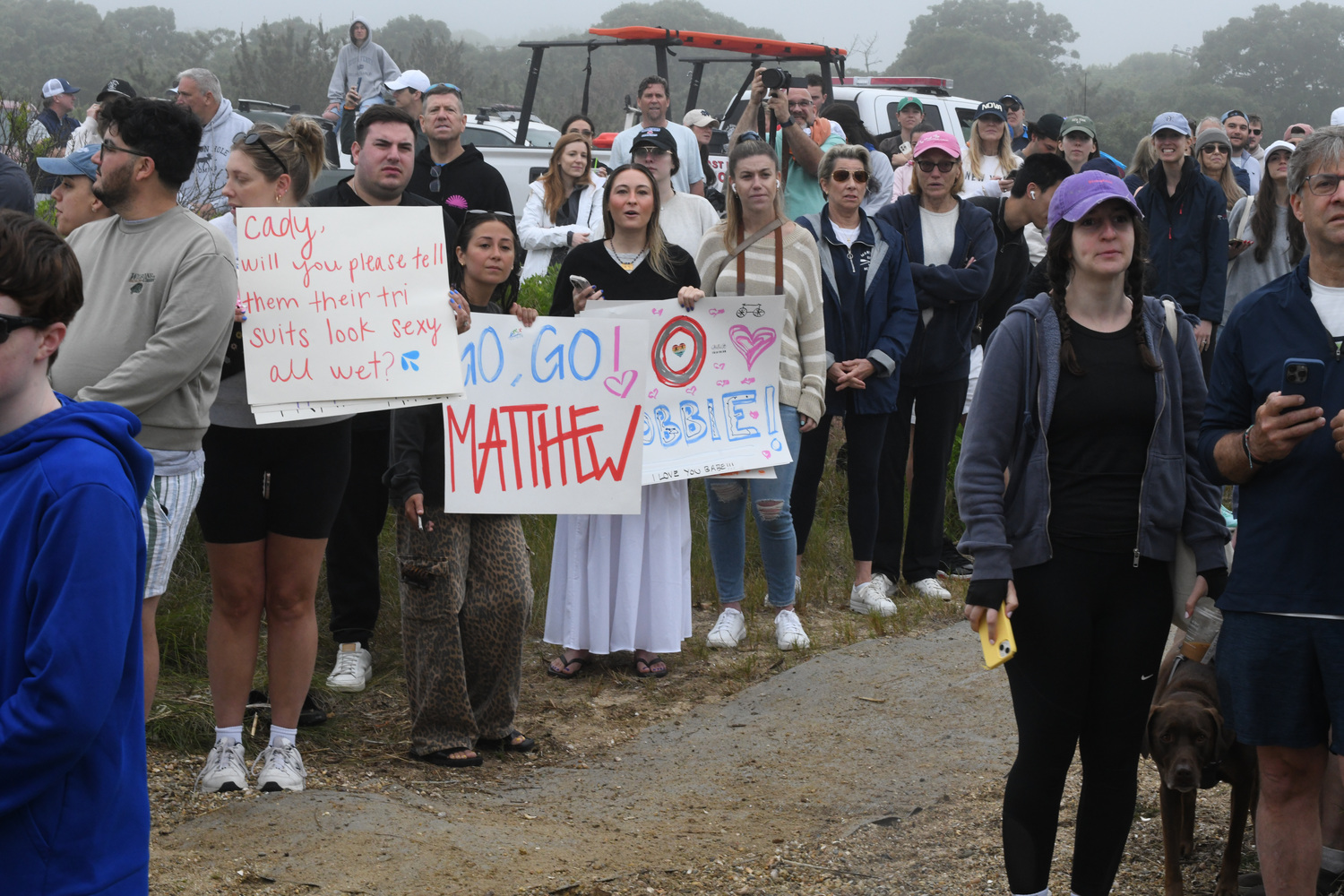 Supporters with signs at the RJA Memorial Mighty Montauk Triathlon on Saturday morning.   DOUG KUNTZ