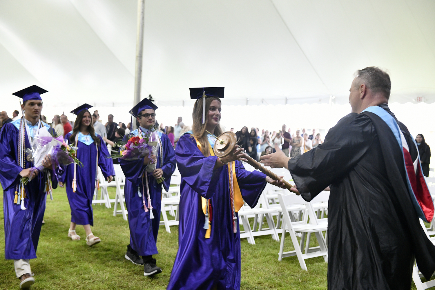 Class President Julia Brandes hands the staff to Principal Christopher Richardt.  DANA SHAW