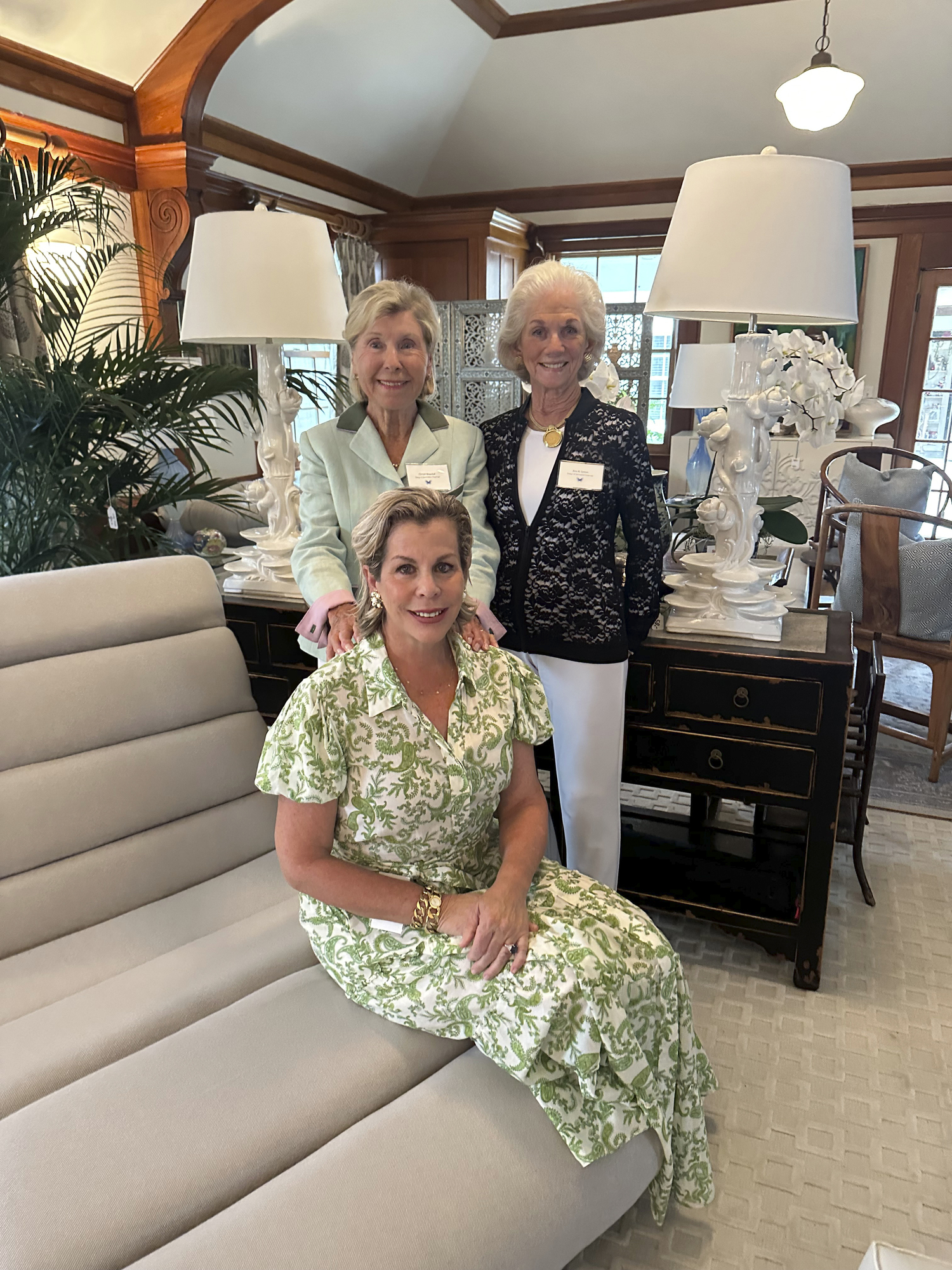 Christl Meszkat and Ann Grimm standing and Barbara Glatt at the DDD event for the Fresh Air Home.
