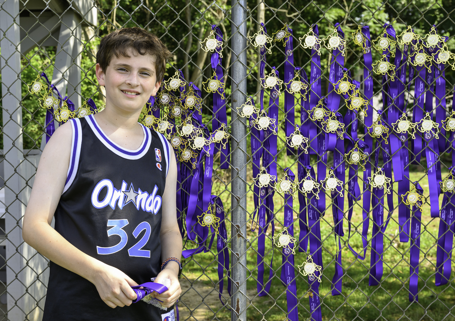 A young volunteer hangs up medals near the finish line.  MARIANNE BARNETT