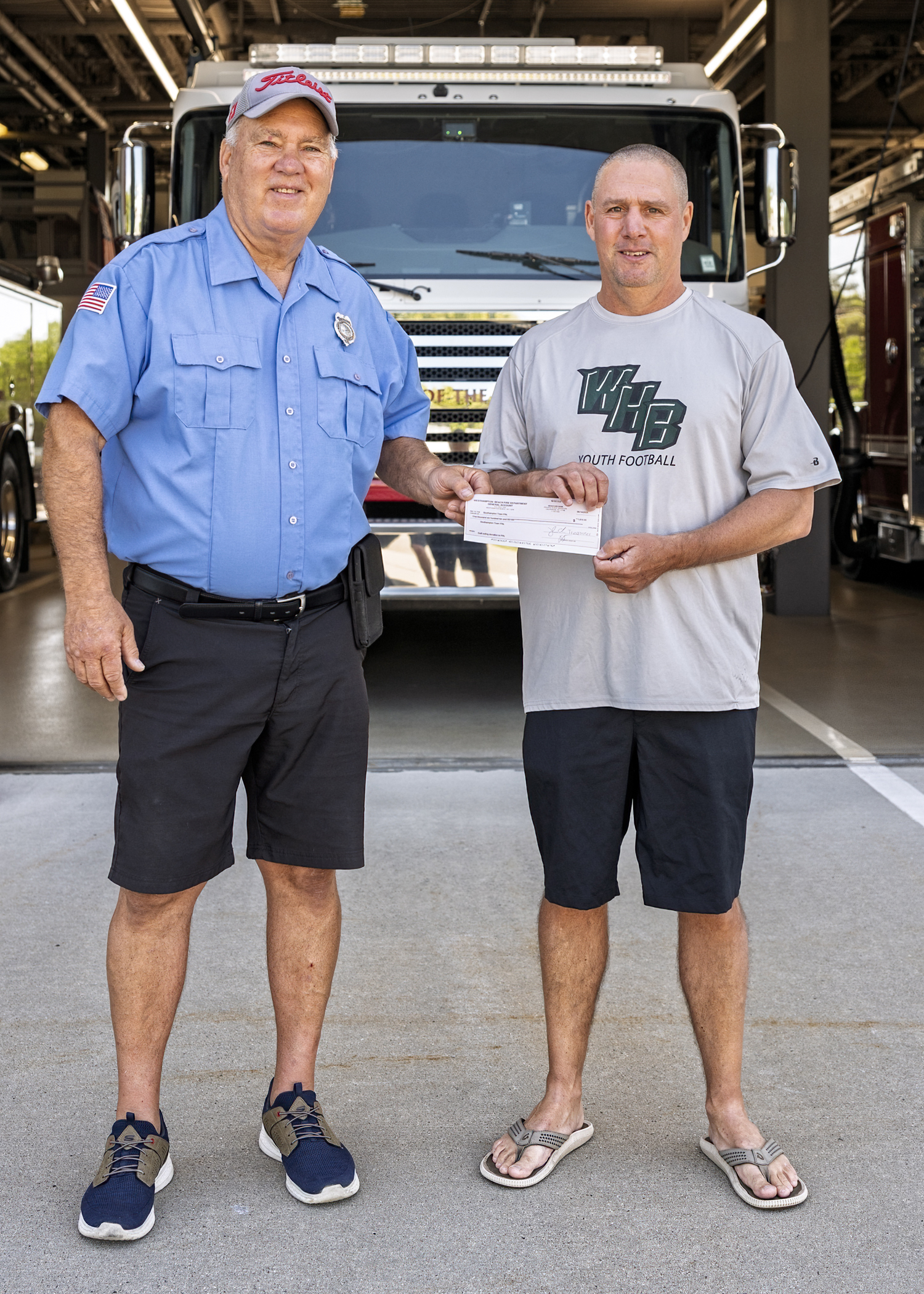 Digger Koziarz, right, treasurer of the Southampton Town P.A.L. was presented with a check for $1610 by Westhampton Beach Fire Department volunteer Jim Kametler, chairman of the department’s annual golf outing, which was held on June 9 at the Westhampton Country Club. The money represented proceeds from the outing’s raffles.   COURTESY WESTHAMPTON BEACH FIRE DEPARTMENT
