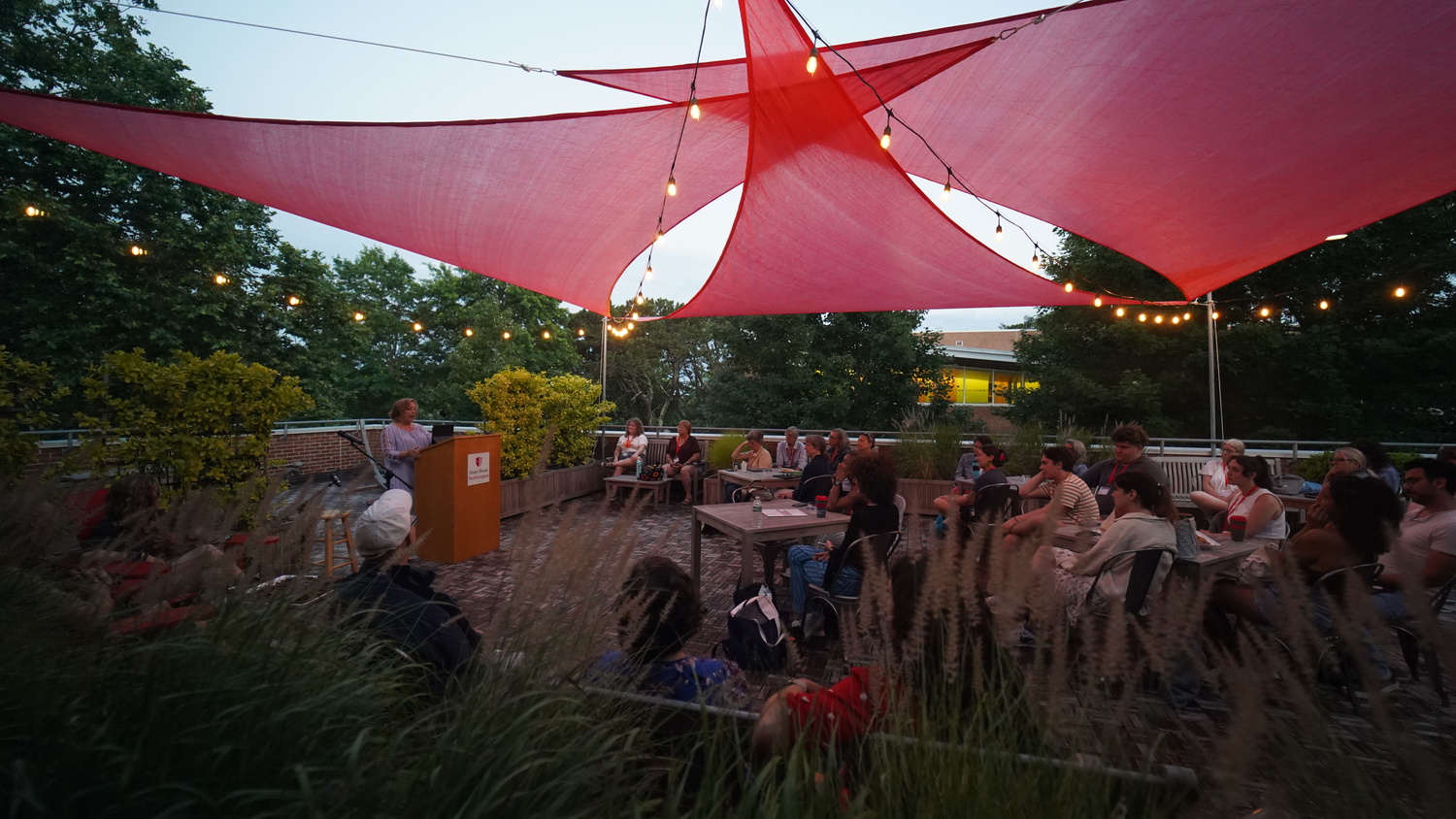 Students listen at Missy's Place, an outdoor patio created in honor of the late Melissa Bank, an author who loved and supported the Southampton Writers Conference. Frank Imperiale photo
