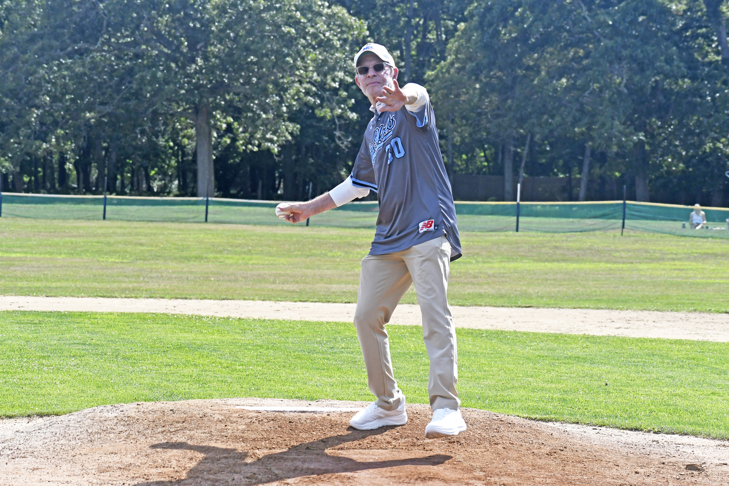 Michael Weisman, who worked for NBC Sports and was inducted into the Sports Broadcasting Hall of Fame in 2017, throws out the first pitch on Saturday afternoon.  DREW BUDD