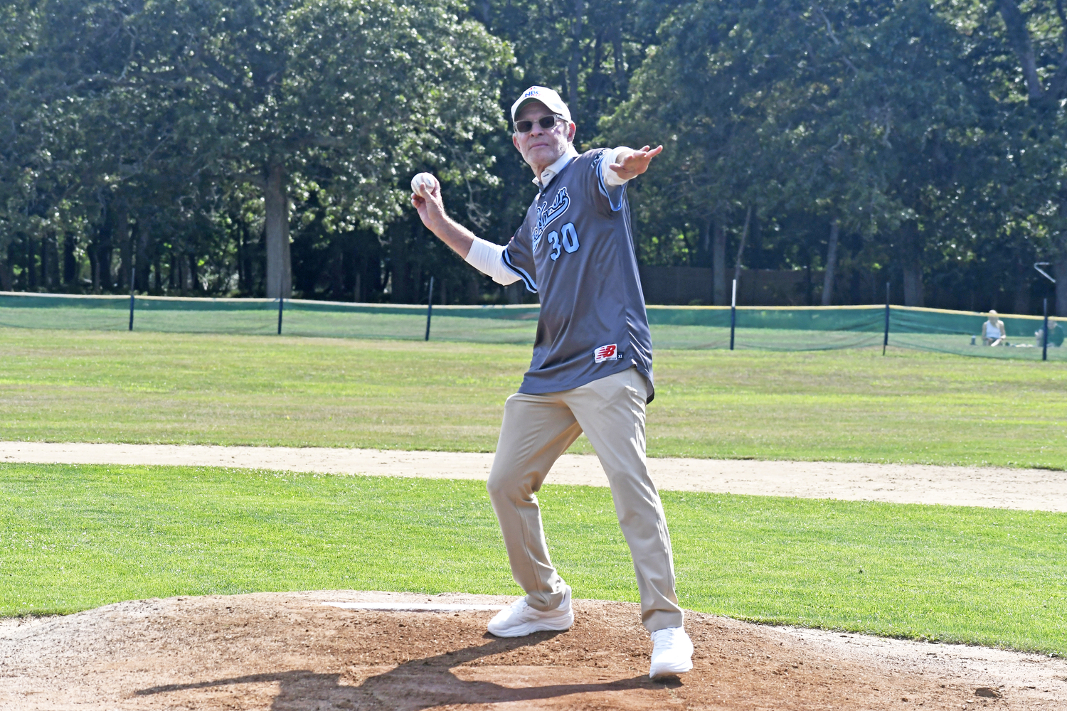 Michael Weisman, who worked for NBC Sports and was inducted into the Sports Broadcasting Hall of Fame in 2017, throws out the first pitch on Saturday afternoon.  DREW BUDD