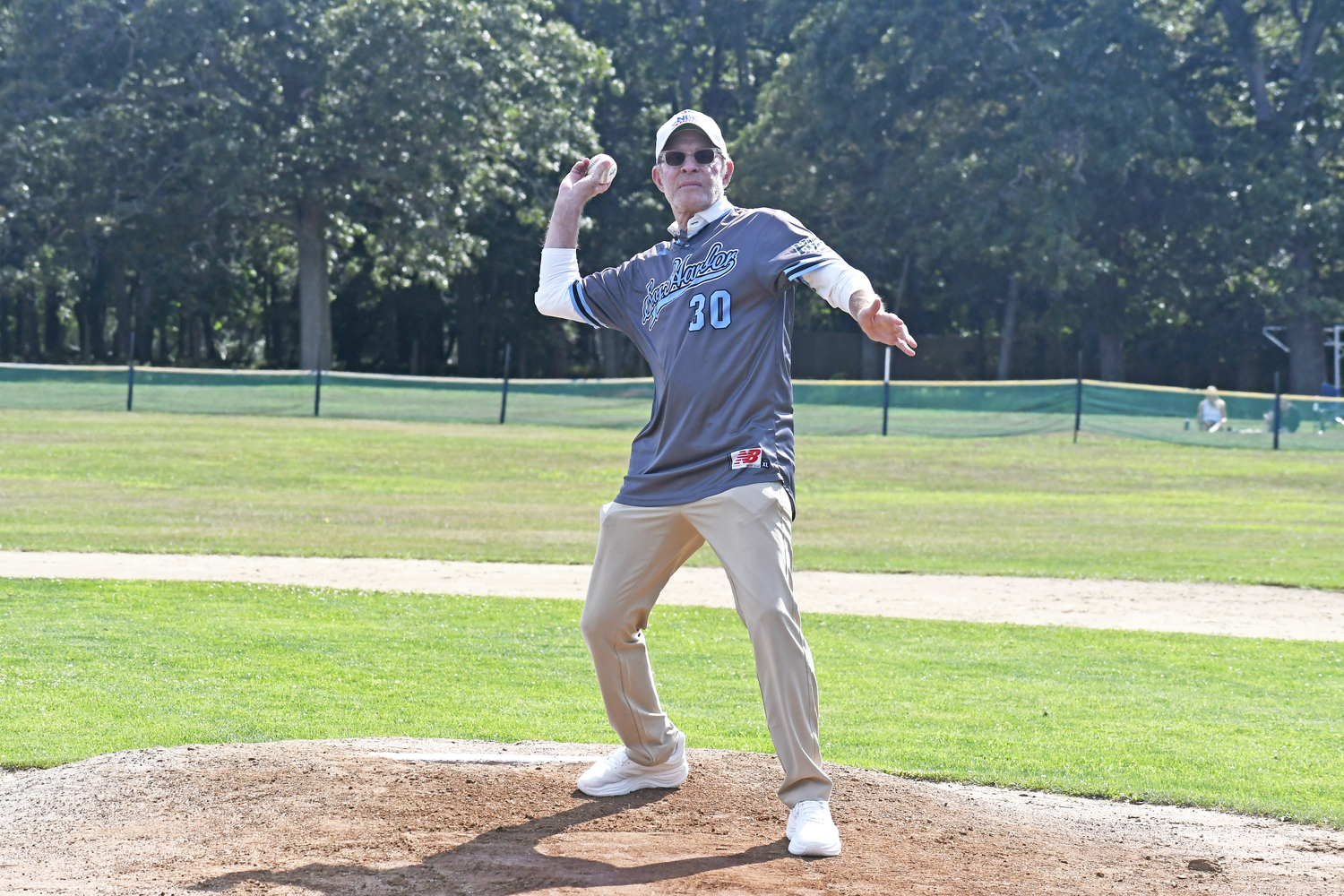 Michael Weisman, who worked for NBC Sports and was inducted into the Sports Broadcasting Hall of Fame in 2017, throws out the first pitch on Saturday afternoon.  DREW BUDD