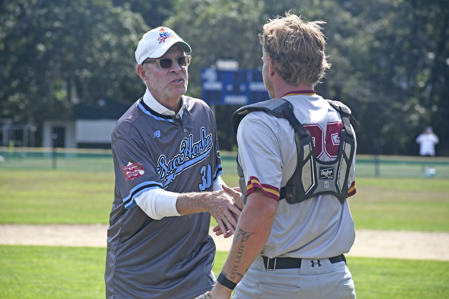 Michael Weisman shakes catcher Nick Pratt's hand after throwing out the first pitch of Saturday afternoon's HCBL All-Star Game at Mashashimuet Park in Sag Harbor.  DREW BUDD