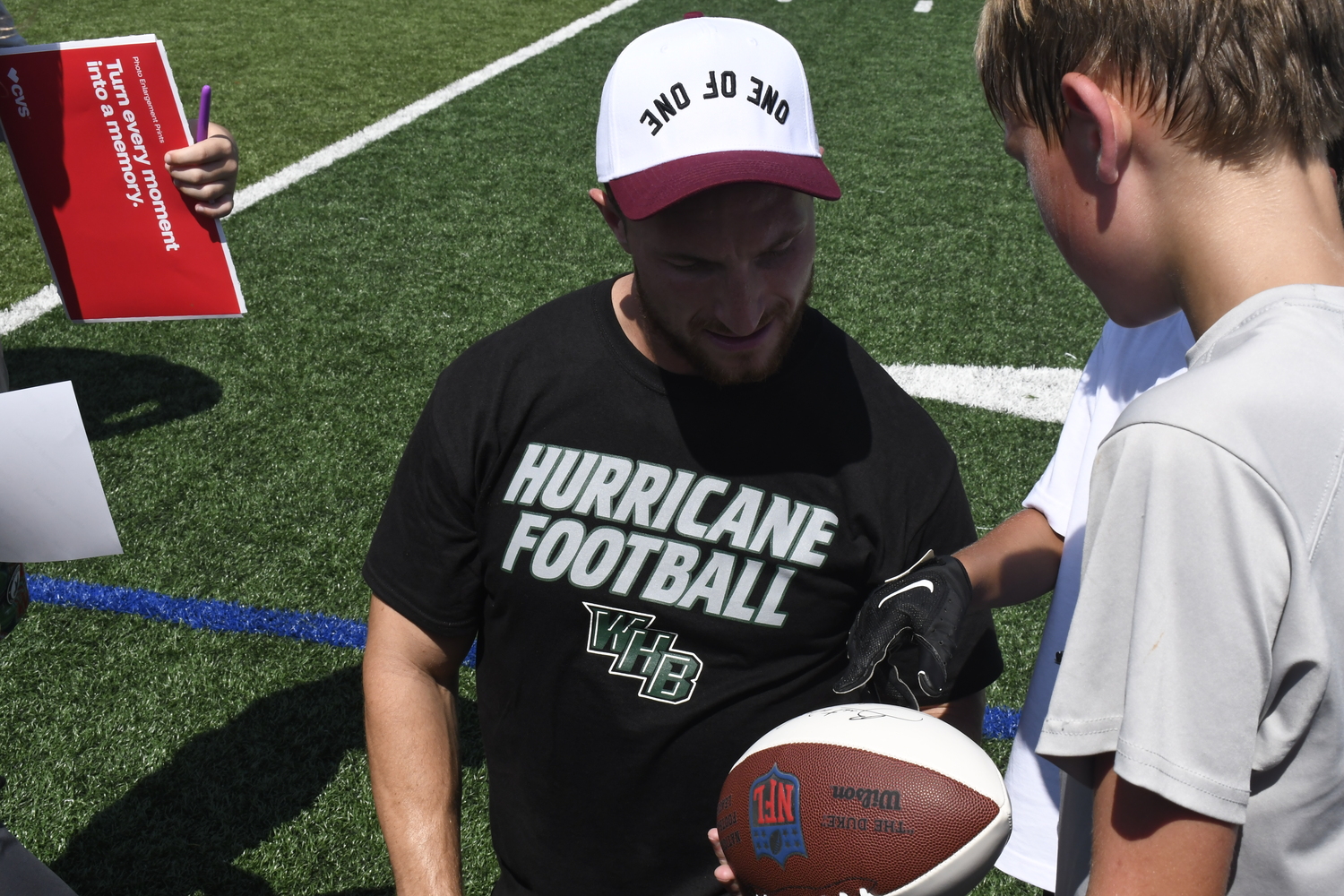 Dylan Laube signs some memorabilia.  DREW BUDD