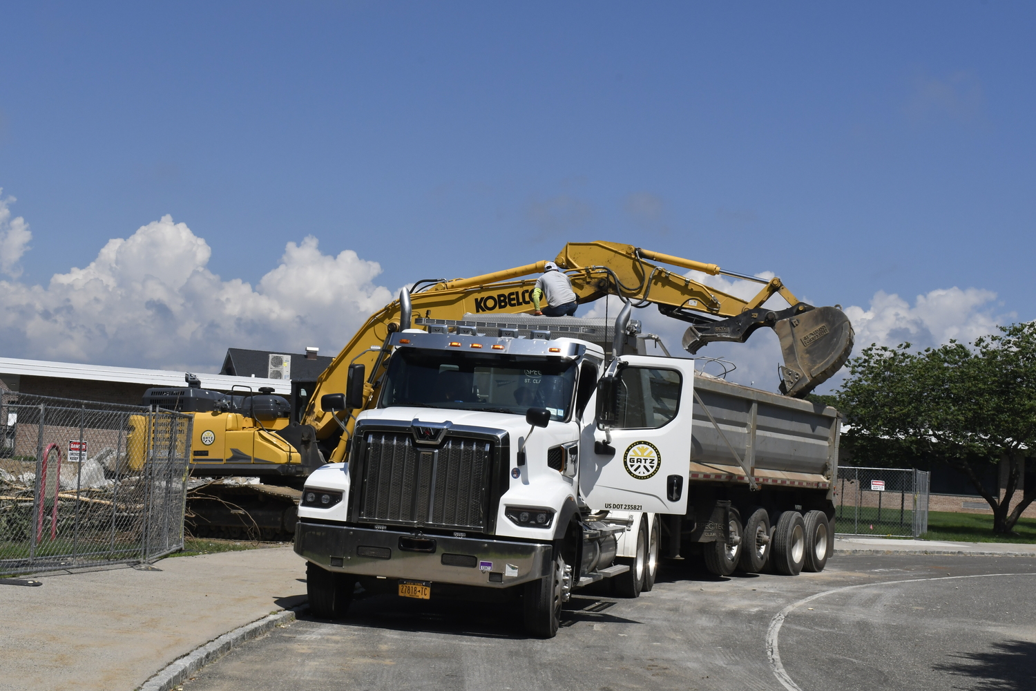 A crane works on demoing portable classrooms at Westhampton Beach Elementary School on July 16. The work had nothing to do with the varsity baseball field located behind the elementary school.  DREW BUDD