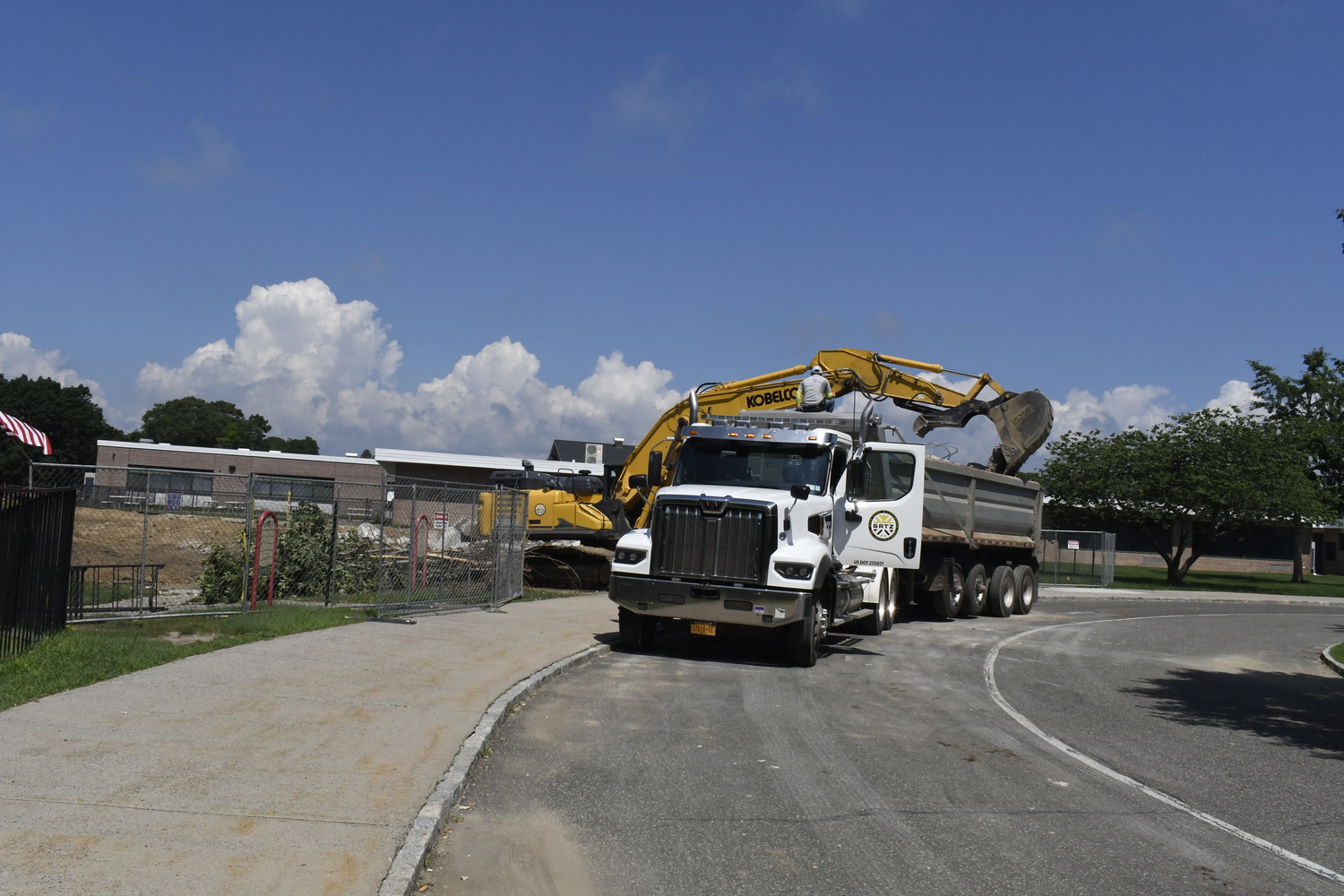 A crane works on demoing portable classrooms at Westhampton Beach Elementary School on July 16. The work had nothing to do with the varsity baseball field located behind the elementary school.  DREW BUDD