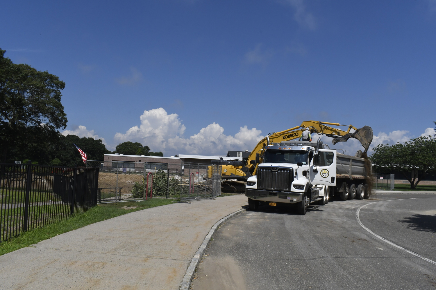 A crane works on demoing portable classrooms at Westhampton Beach Elementary School on July 16. The work had nothing to do with the varsity baseball field located behind the elementary school.  DREW BUDD