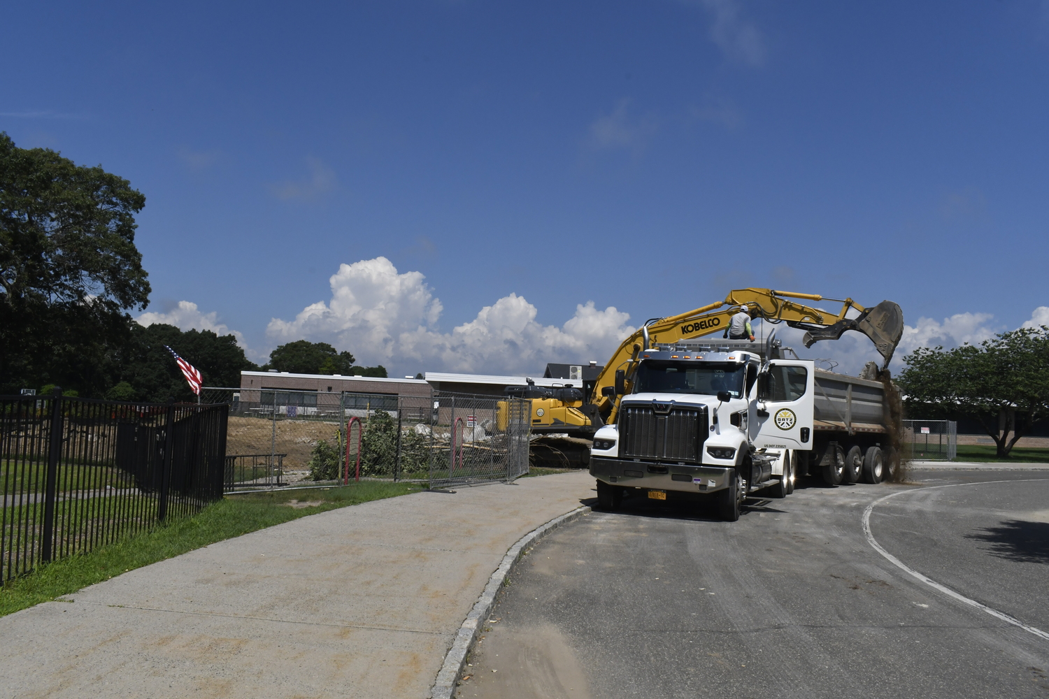 A crane works on demoing portable classrooms at Westhampton Beach Elementary School on July 16. The work had nothing to do with the varsity baseball field located behind the elementary school.  DREW BUDD