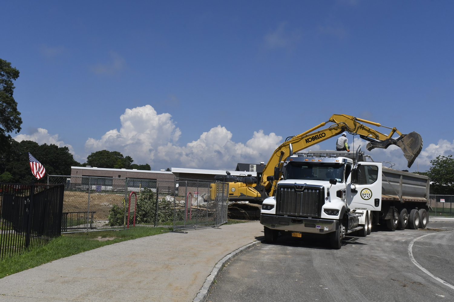 A crane works on demoing portable classrooms at Westhampton Beach Elementary School on July 16. The work had nothing to do with the varsity baseball field located behind the elementary school.  DREW BUDD